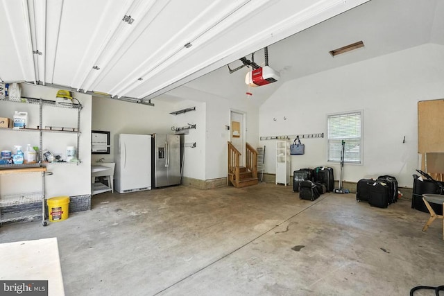 6205 Patrician Ct, Fredericksburg, VA 22407 - garage featuring stainless steel fridge, freestanding refrigerator, and a garage door opener