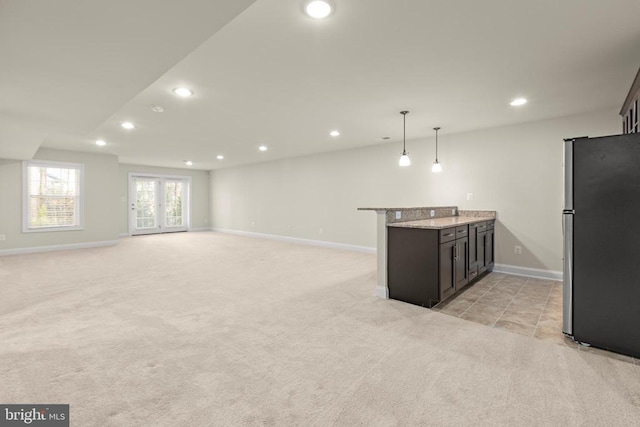 interior space featuring light stone counters, freestanding refrigerator, light colored carpet, and recessed lighting