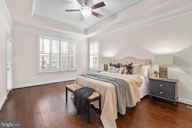 bedroom with hardwood / wood-style flooring, baseboards, ornamental molding, and a raised ceiling