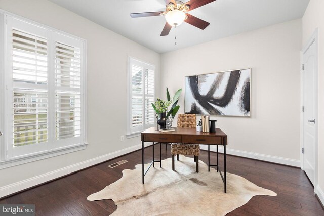 office area with a ceiling fan, visible vents, baseboards, and wood finished floors