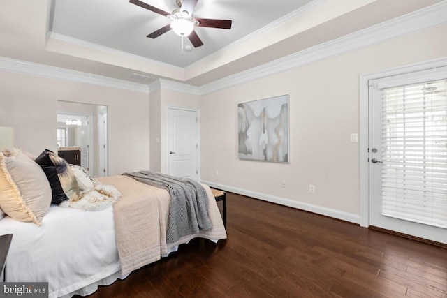 bedroom featuring a tray ceiling, dark wood-style flooring, crown molding, and baseboards