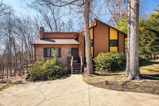 view of front of home featuring brick siding and a chimney