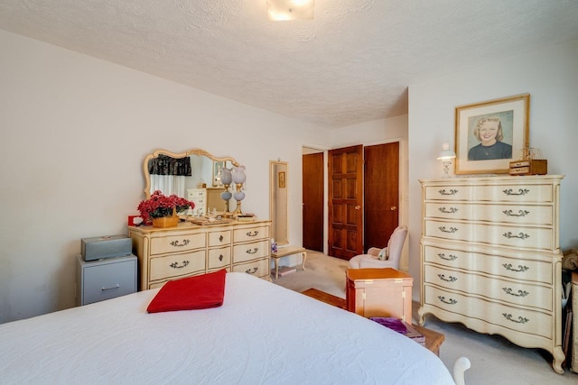 bedroom featuring carpet, a textured ceiling, and a closet