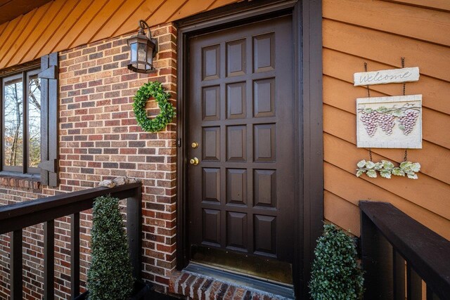 doorway to property featuring brick siding