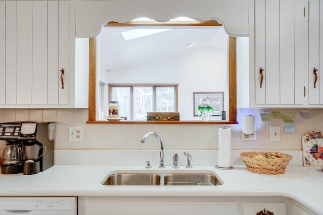kitchen featuring a sink, light countertops, white dishwasher, and white cabinets