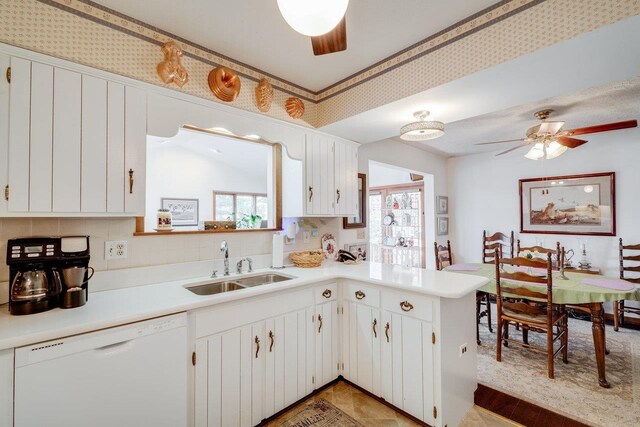 kitchen featuring light countertops, a ceiling fan, a sink, and white dishwasher