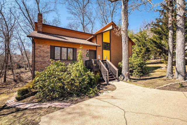 view of front of house featuring brick siding and a chimney