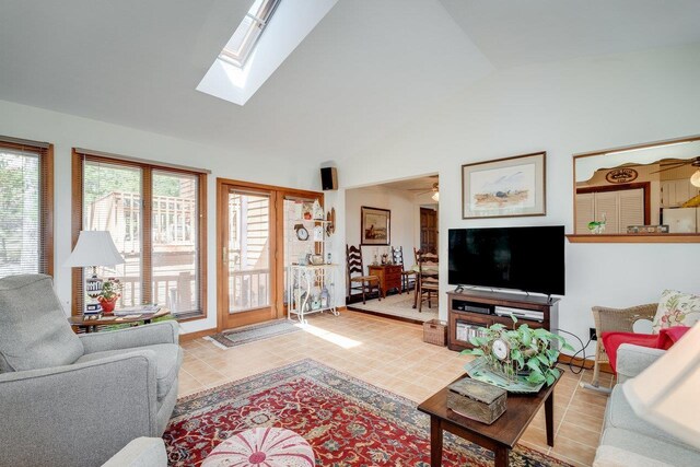 living area featuring light tile patterned flooring, a skylight, and high vaulted ceiling
