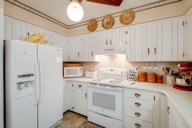 kitchen with white cabinets, white appliances, under cabinet range hood, light countertops, and decorative backsplash