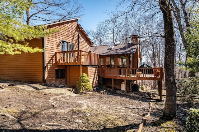 rear view of house with a deck and a chimney