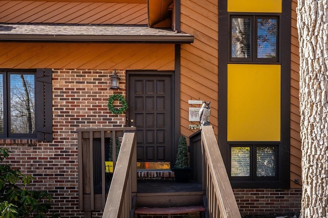 doorway to property featuring brick siding
