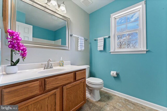 bathroom featuring vanity, baseboards, and toilet