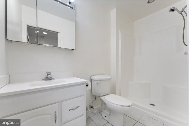 full bath featuring a shower stall, toilet, vanity, and baseboards