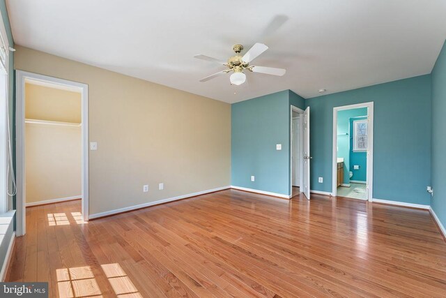 unfurnished bedroom with light wood-style flooring, baseboards, and a ceiling fan