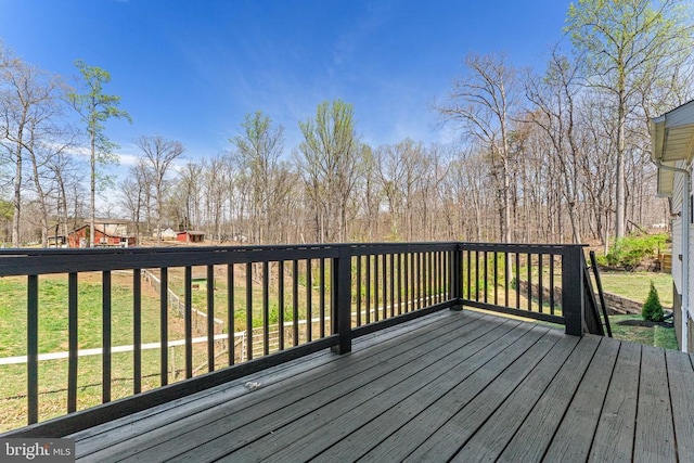 wooden deck featuring a lawn