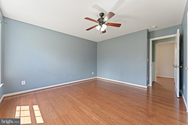 empty room featuring a ceiling fan, wood finished floors, and baseboards