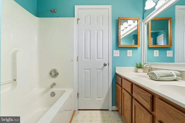 bathroom with tile patterned floors, double vanity, and  shower combination