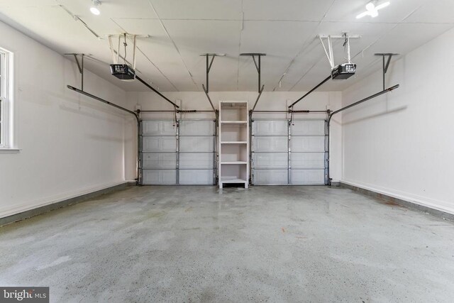 garage featuring a garage door opener and baseboards