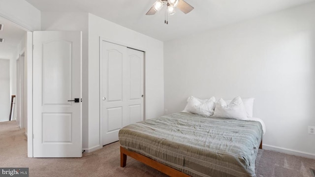 bedroom featuring carpet floors, a closet, baseboards, and a ceiling fan