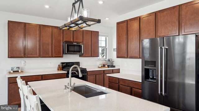 kitchen with high quality fridge, black gas range oven, a sink, light countertops, and recessed lighting