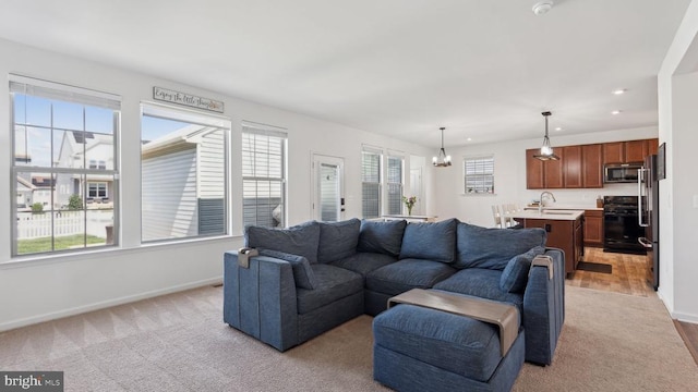 living area with baseboards, recessed lighting, a chandelier, and light colored carpet