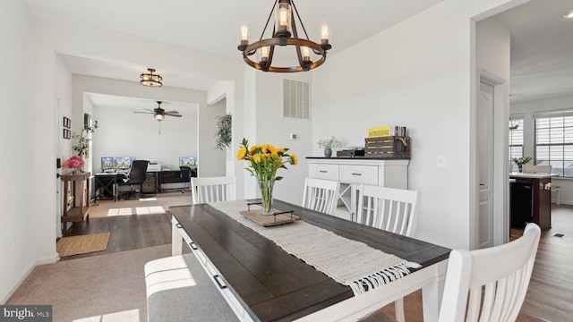 dining area featuring an office area, a chandelier, wood finished floors, and a ceiling fan