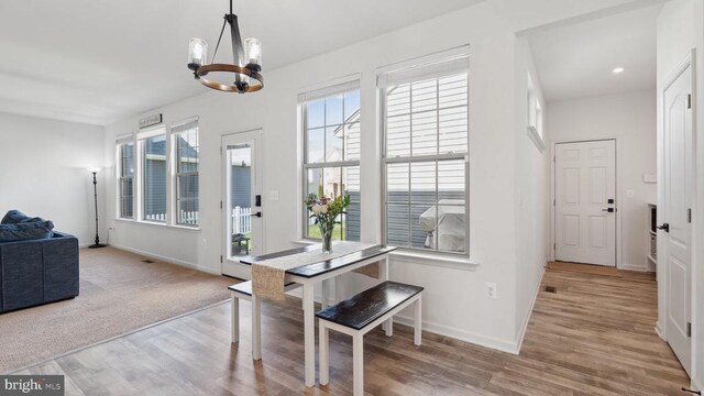 dining room featuring a chandelier, wood finished floors, baseboards, and recessed lighting