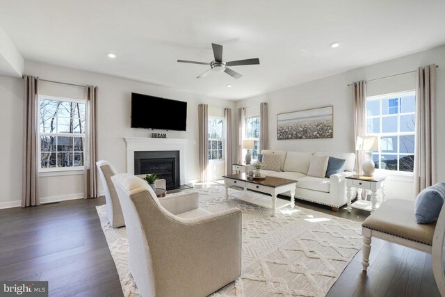 living room featuring recessed lighting, light wood finished floors, a ceiling fan, baseboards, and a fireplace with flush hearth