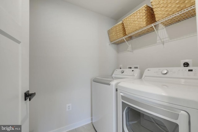 washroom with washing machine and clothes dryer, laundry area, and baseboards