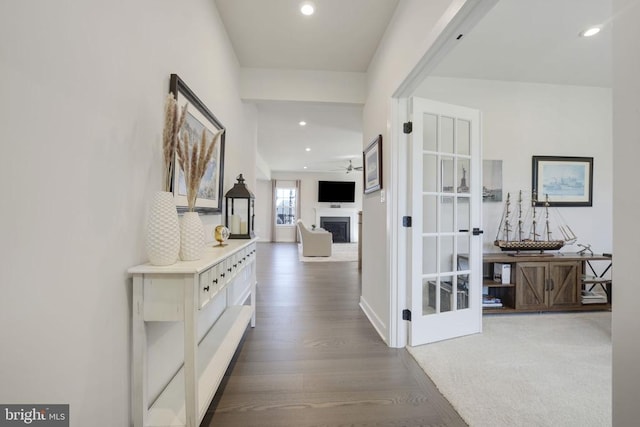 hallway featuring baseboards, recessed lighting, and wood finished floors