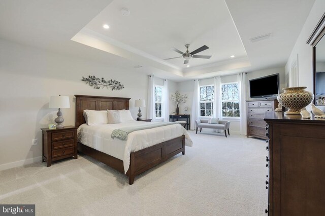 bedroom with a ceiling fan, a tray ceiling, recessed lighting, visible vents, and light carpet