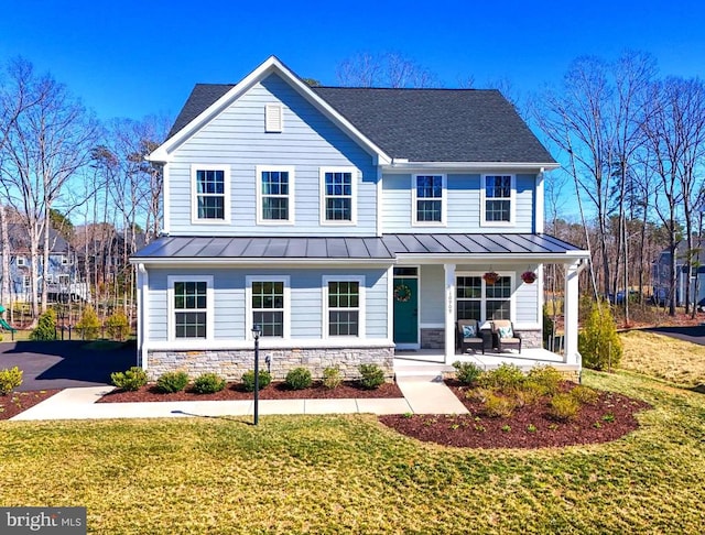 view of front of house with a front lawn, a porch, metal roof, and a standing seam roof