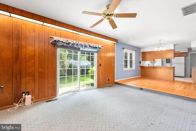 307 Butternut Dr, Fredericksburg, VA 22408 - unfurnished living room with a chandelier, carpet floors, a ceiling fan, and wood walls