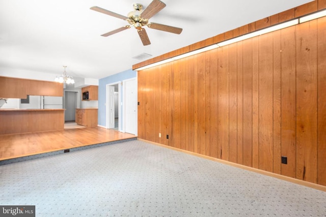 307 Butternut Dr, Fredericksburg, VA 22408 - unfurnished living room with a chandelier, carpet flooring, a ceiling fan, and wooden walls