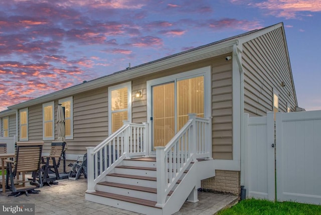 8859 Marlow Dr, Spotsylvania, VA 22551 - back of property at dusk featuring a patio and a gate