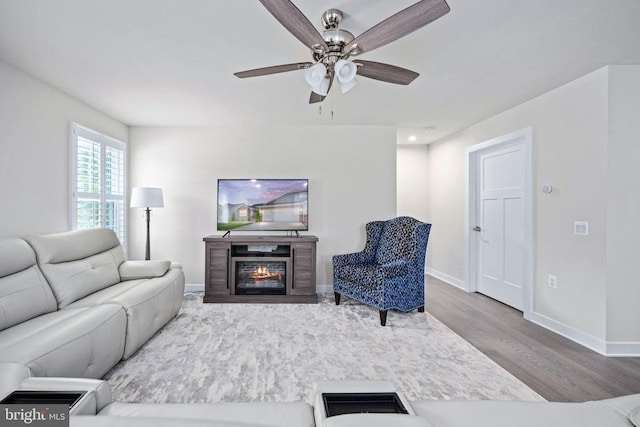 8859 Marlow Dr, Spotsylvania, VA 22551 - living area with wood finished floors, a ceiling fan, and a glass covered fireplace
