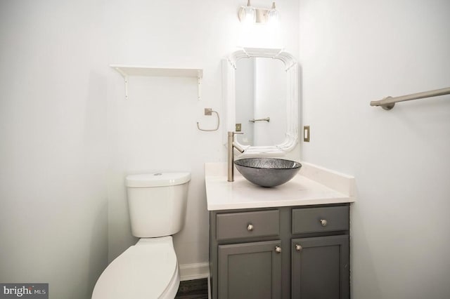 half bath featuring vanity and toilet