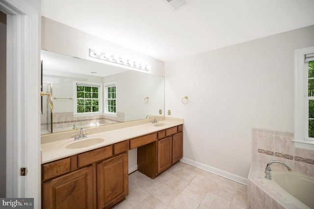 bathroom with a bath, tile patterned flooring, double vanity, and baseboards