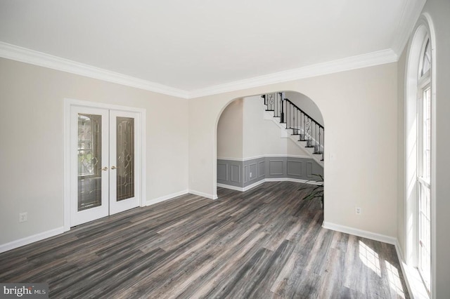 unfurnished room featuring arched walkways, dark wood-style flooring, crown molding, stairs, and french doors