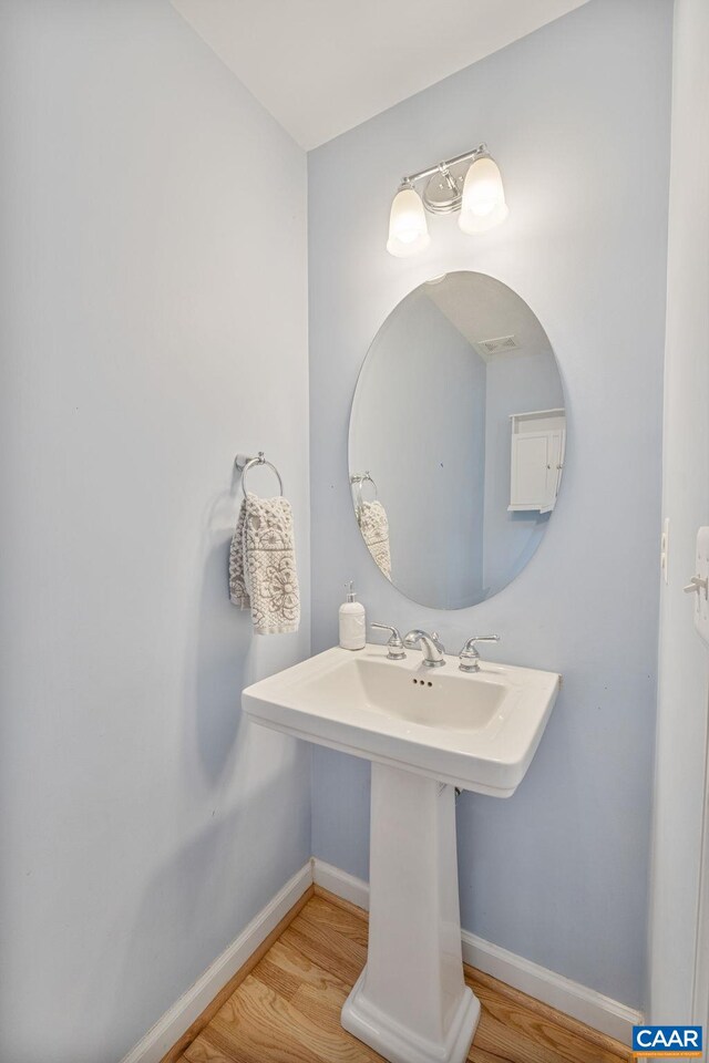 bathroom with baseboards and wood finished floors