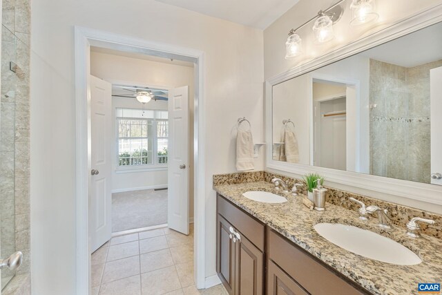 bathroom with a ceiling fan, a tile shower, tile patterned floors, and a sink