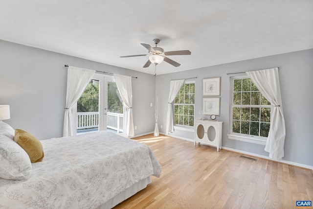 bedroom with access to outside, baseboards, visible vents, and wood finished floors