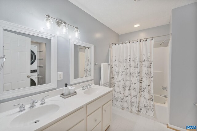 bathroom featuring double vanity, shower / tub combo, stacked washer / drying machine, and a sink