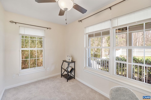 carpeted spare room with ceiling fan and baseboards