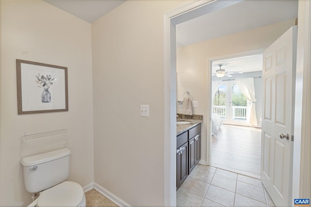 half bath featuring toilet, baseboards, vanity, and tile patterned flooring
