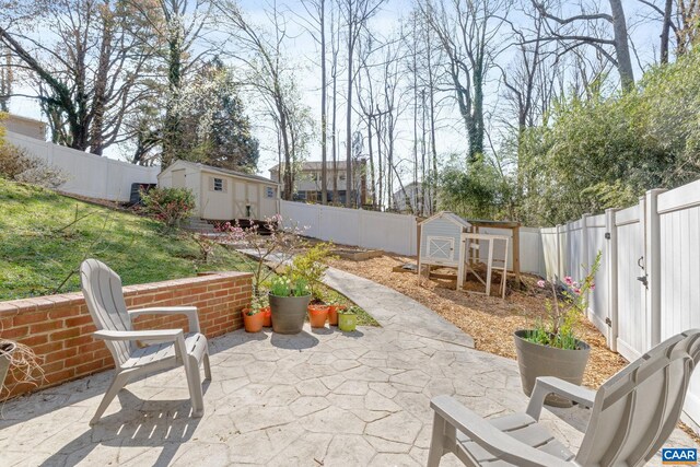 view of patio / terrace with an outbuilding, a fenced backyard, and a storage unit