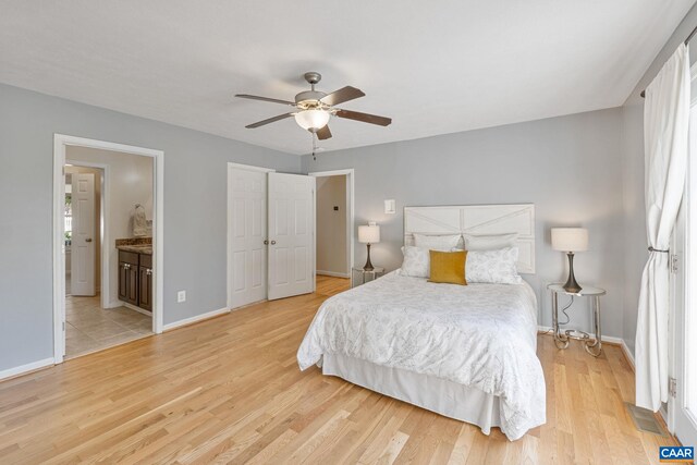 bedroom featuring baseboards, multiple windows, and light wood-style floors