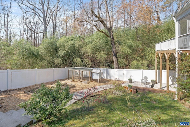 view of yard featuring a fenced backyard, a deck, and an outbuilding