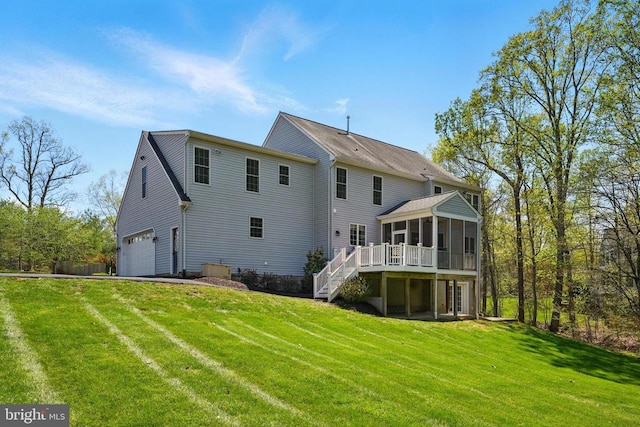 back of house featuring a sunroom, stairs, an attached garage, a deck, and a yard