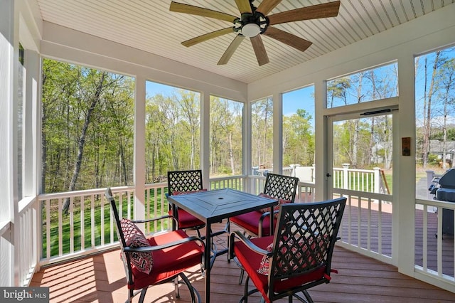 sunroom / solarium featuring ceiling fan and outdoor dining area